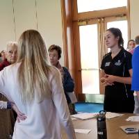 A young woman is speaking to an older woman